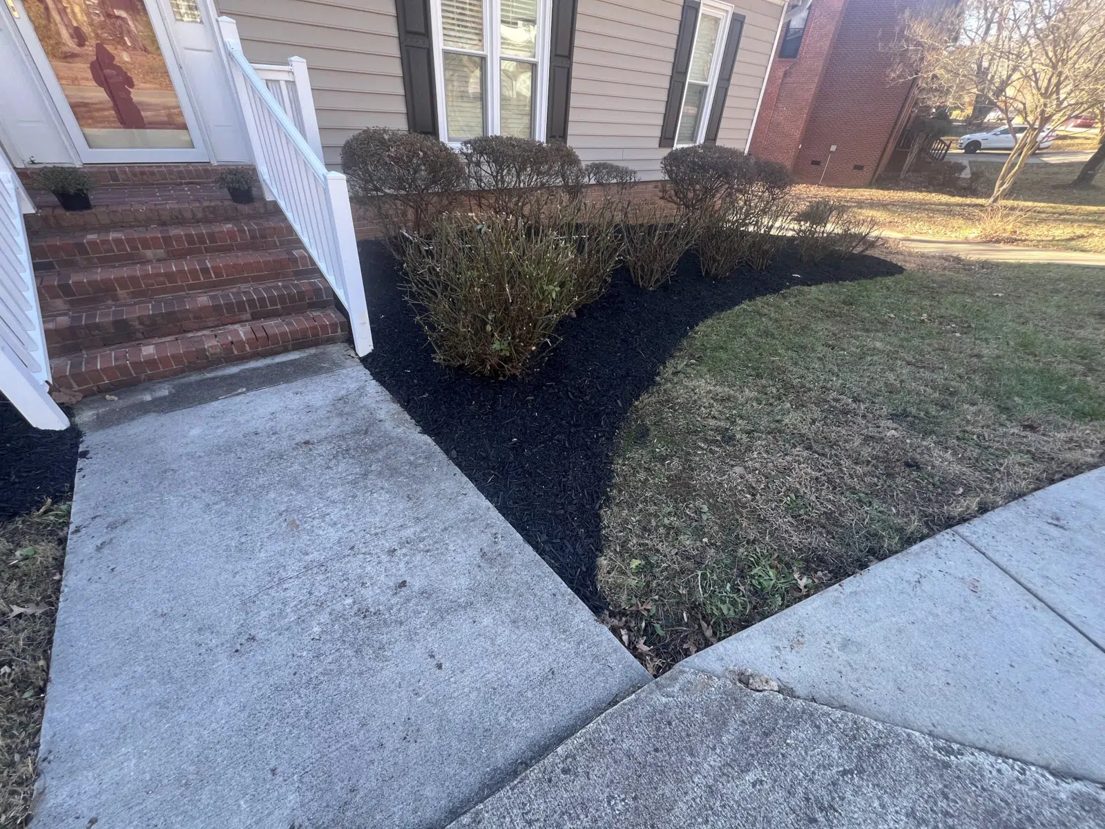 Fresh black mulch bed along a home's walkway — Your Way Lawn and Tree in Greensboro